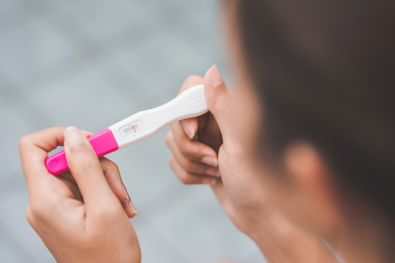 young woman looking at a pregnancy test