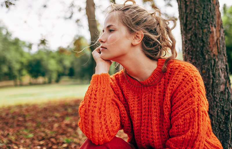 young woman blowing dandelions 